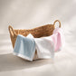 white blue and pink baby security blankets on basket