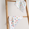 Floral-patterned baby blankets on a wooden ladder against a white background